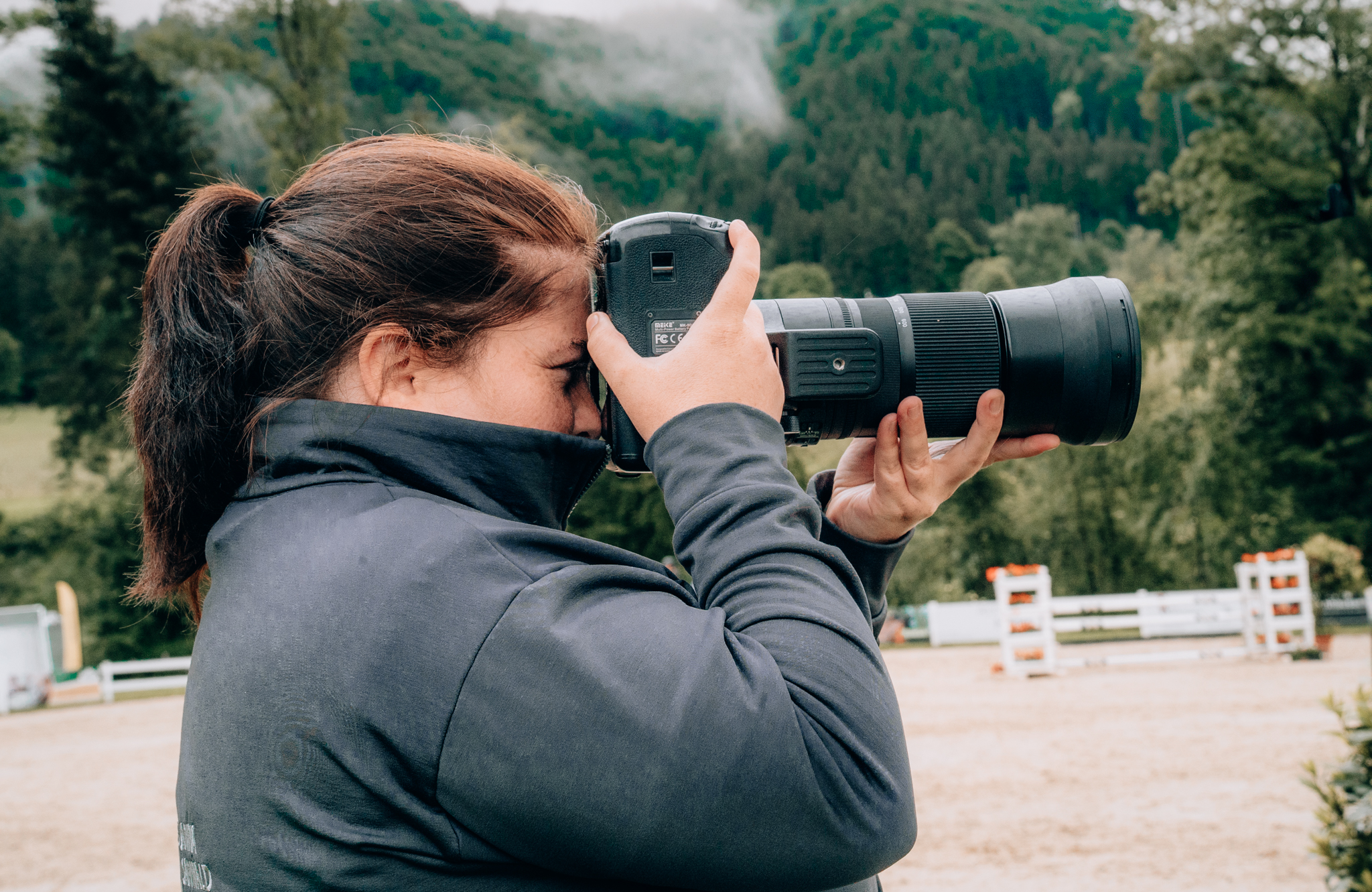 Professionelle Fotografin bei der Turnierfotografie mit Teleobjektiv – Pferdefotografie und Reitsportfotografie bei Outdoor-Reitturnier